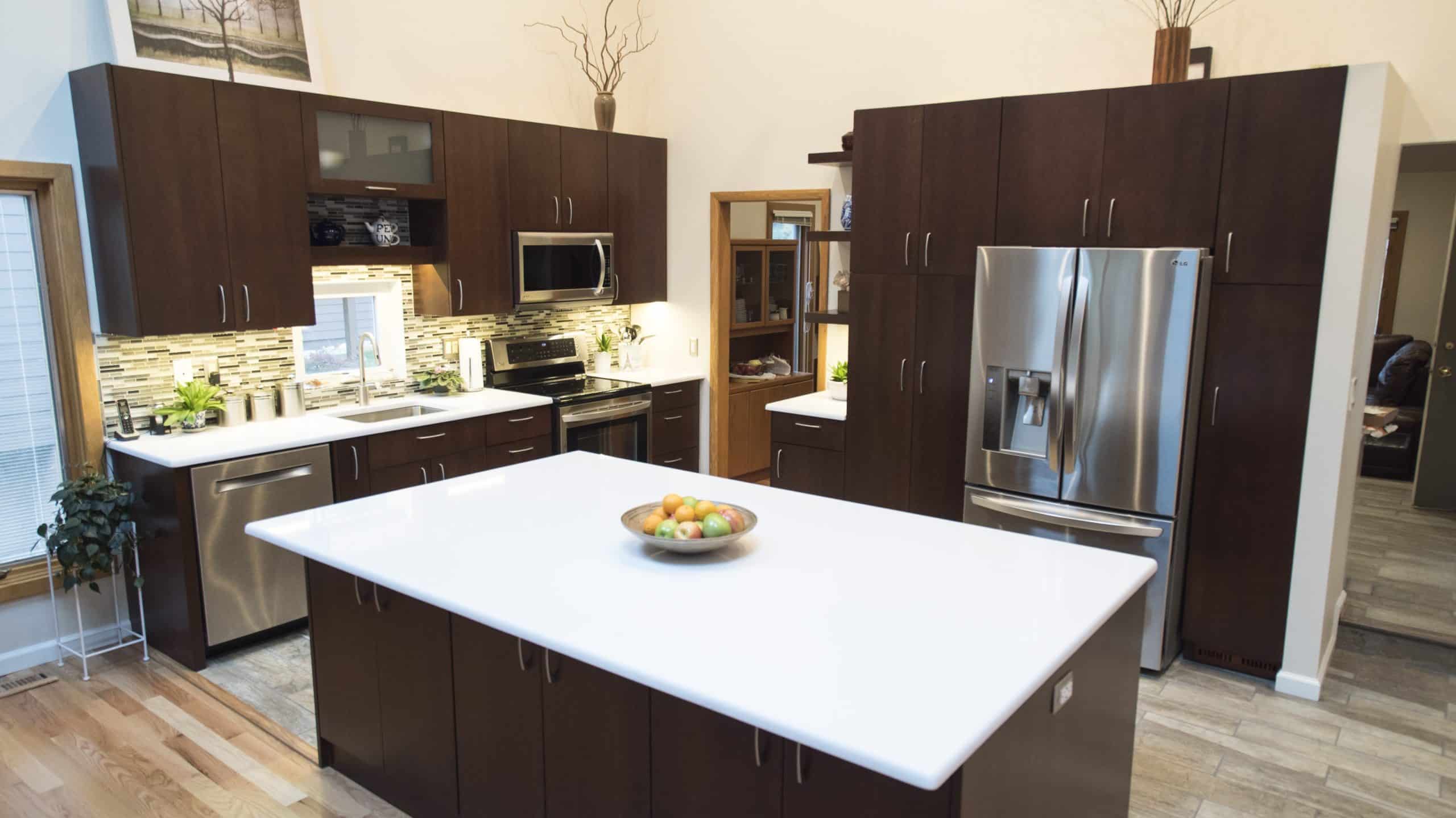 Modern kitchen with white counter top and stainless steel appliances