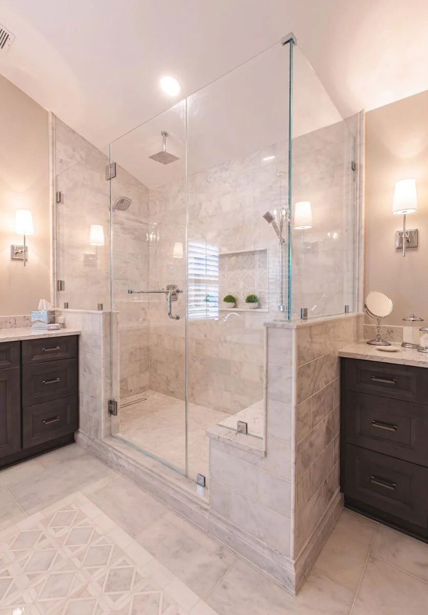 Full vertical view of a custom marble walk-in shower with rainfall head and glass door in an Ashburn VA bathroom remodel.