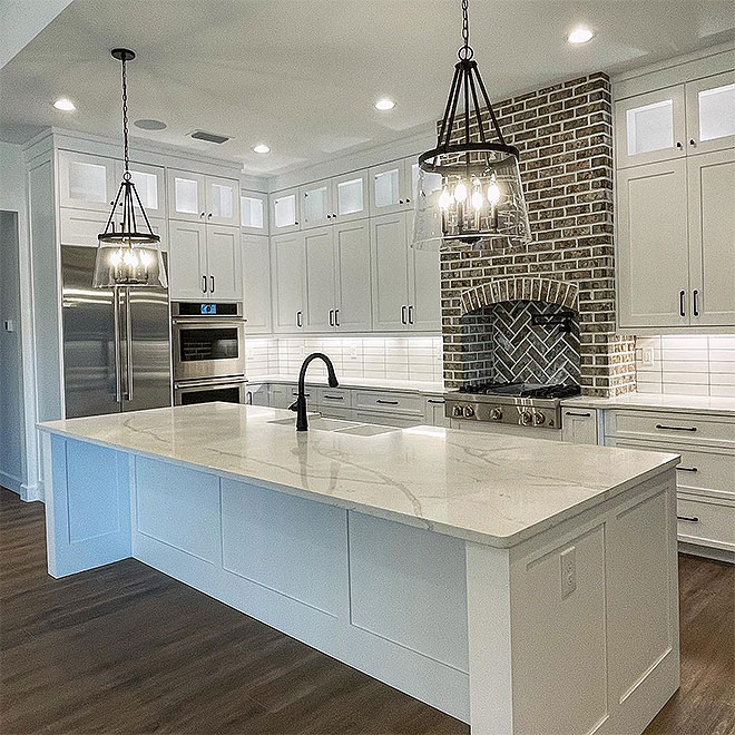 Q Quartz 9 Modern kitchen featuring white cabinets and a charming brick wall