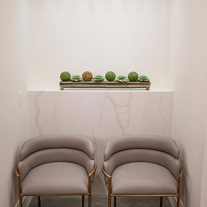 Q Quartz 11 Cozy seating area with two chairs and a shelf above them in a small room