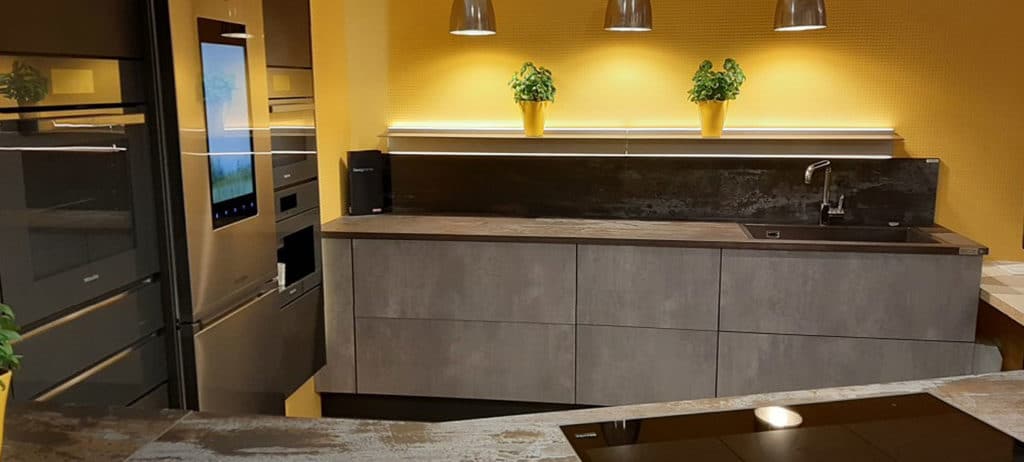 Dekton 1 A kitchen with yellow walls and a sink.