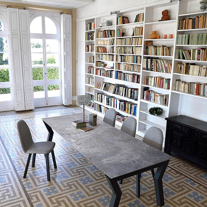Dekton 11 A table and chairs arranged in front of a bookcase.