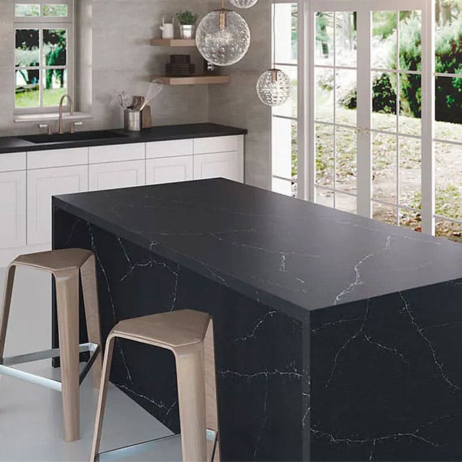 Silestone 11 A stylish kitchen with a black counter top and seating area.
