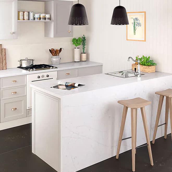 Silestone 9 White kitchen with marble island and wooden stools.