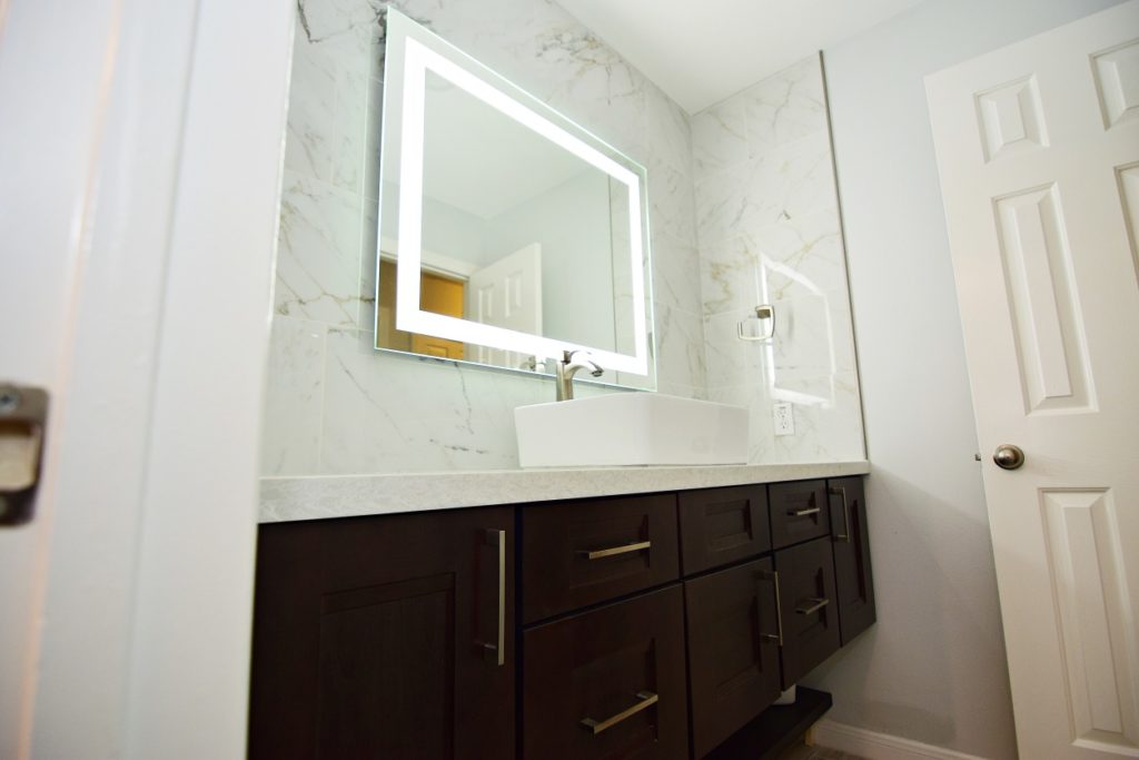 Latest Small Bathroom Remodeling Cost this 2022 150 Marble countertop and large mirror in a bathroom setting