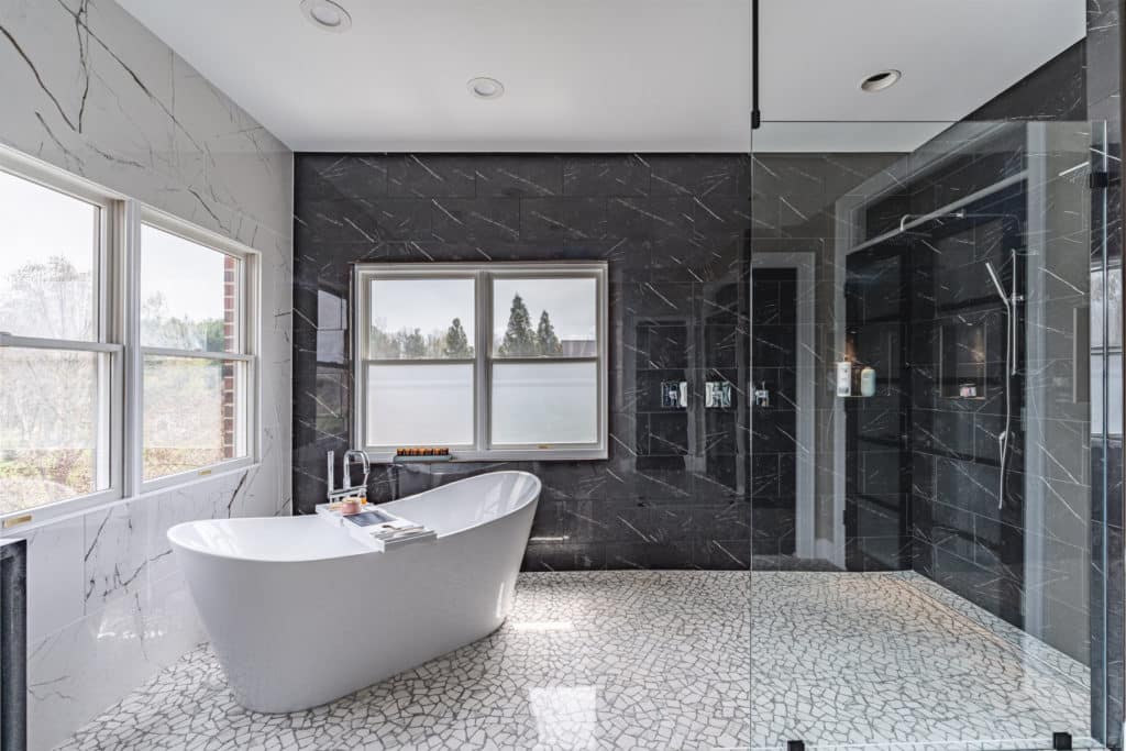 Minimalist Designs To Consider For Your Bathroom Remodeling Project 31 a bathroom with a large tub and a marble walls