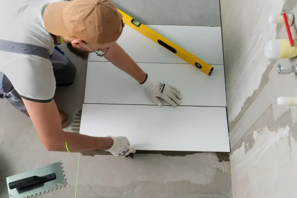man with hat remodels bathroom floor