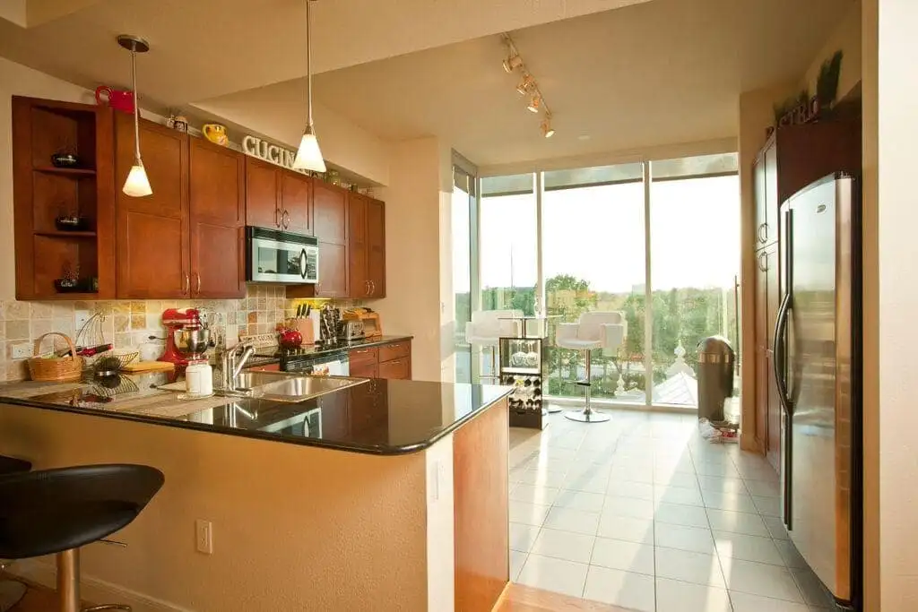 lighted kitchen with walnut cabinets and large windows