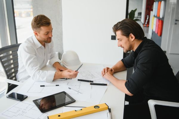 About us 2 Architect discussing project with client.